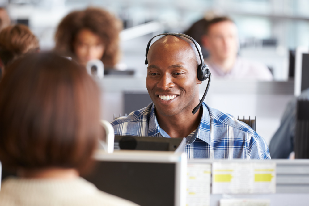 Man in a call center answers a customer inquiry.